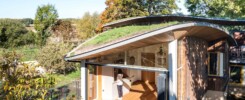 Изогнутые зеленые крыши покрывают этот домик на берегу Ручья